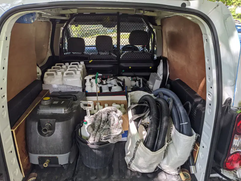 Carpet cleaning machine, hoses and cleaning solutions packed in the back of our van
